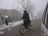 A man rides his bicycle amid dense fog in Srinagar, Indian Administered Kashmir on 15 January 2020. The temprature in Srinagar dipped to -8....