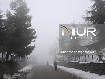 People walk  amid dense fog in Srinagar, Indian Administered Kashmir on 15 January 2020. The temprature in Srinagar dipped to -8.4 Celsius o...