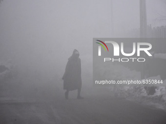 A man walks amid dense fog in Srinagar, Indian Administered Kashmir on 15 January 2020. The temprature in Srinagar dipped to -8.4 Celsius on...
