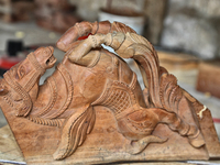 Carved wooden figures of horses wait to adorn a traditional Hindu wooden chariot during the construction of a chariot at a home-based worksh...
