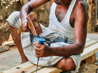 Workers construct a traditional Hindu wooden chariot at a home-based workshop in Thirunelveli, Jaffna, Sri Lanka. This chariot will be used...