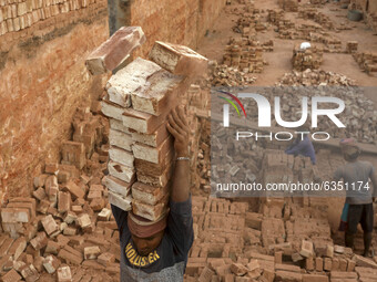A man stacks eighteen bricks on his head while working at in brickfields Narayanganj near Dhaka Bangladesh on January 15, 2021. (