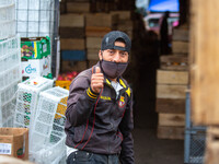 Man poses smiling, he dedicates the work of unloading the sacks of fruits that arrive at this food enclosure. On January 15, 2021 in Quito,...