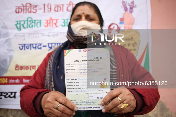 A health worker woman Shows her vaccination record card after get vaccinated,  at a hospital  in the outskirts of Allahabad on January 16,20...