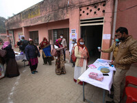 Health workers women stand in a queue to show their identity card before get vaccinated,  at a hospital  in the outskirts of Allahabad on Ja...