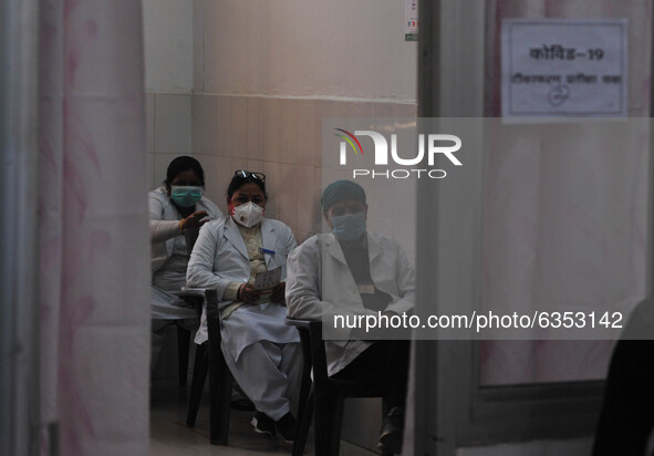 Health workers sit in a queue to wait their turn  before get vaccinated,  at a hospital  in the outskirts of Allahabad on January 16,2021.In...