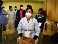A medical worker shows status card after getting a Covid-19 coronavirus vaccine at a hospital in New Delhi on January 16, 2021. As India beg...
