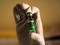 A vaccinator holds a vial of Serum Institute of India's (SII) COVID-19 vaccine called 'Covishield', during the vaccination programme at a ho...