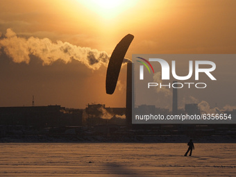 A man rides a kite on the ice of the Gulf of Finland. The temperatures have reached minus fifteen degrees Celsius in St. Petersburg, Russia,...