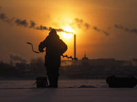 A man is fishing on the ice of the Gulf of Finland. The temperatures have reached minus fifteen degrees Celsius in St. Petersburg, Russia, o...