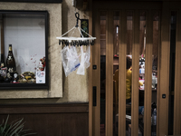 Disposable gloves and plastic bags are hung on a pinch hanger in front of a closed Japanese bar at nightlife district in Tokyo, Japan on 11...