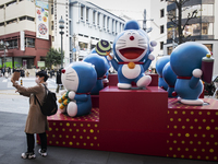 Man wearing a protective face mask takes his selfie with exhibit of cartoon characters at the shopping district in Tokyo, Japan on 16 Januar...