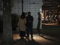A couple observes the statue at the deserted park in Tokyo, Japan on 11 January 2021. (