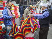 A vendor sell winter blankets to customers in Dhaka on January 15, 2021. After an unusual and sudden rise in the mercury, the intensity of t...
