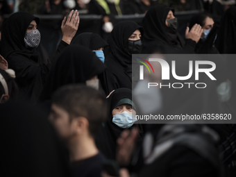 An Iranian woman wearing a protective face mask looks on while attending a religious ceremony to commemorate the death anniversary of Fatima...