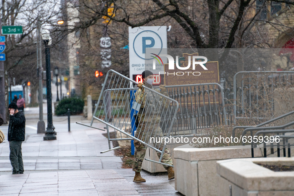 An Ohio National Guard soldiers carries fencing during an armed protest at the Ohio Statehouse ahead of the inauguration of President-elect...