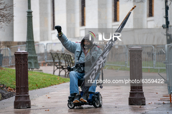 A man in a wheelchair carrying a Black Lives Matter flag is seen during an armed protest at the Ohio Statehouse ahead of the inauguration of...