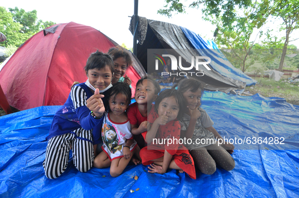 Children who survived the earthquake without wearing masks played at the emergency shelter at the evacuation post, in Mamuju Regency, West S...