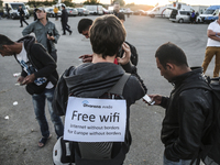 A volunteer offers free wifi to migrants who wait to enter the transfer camp in Opatovac near border crossing point between Serbia and Croat...