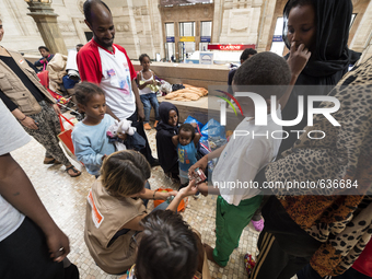 A volunteer provides food to children on 12 June, 2015 in Milan, Italy. (