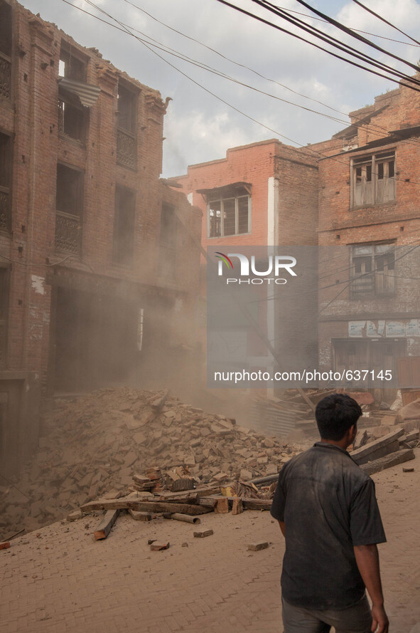 A man watches neighbors demolish destroyed houses in Bhaktapur, South of Kathmandu. Nepal, 5/31/2015. John Fredricks 