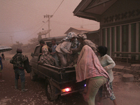 Residents poured into the car to save themselves from the dust of volcanic material that comes out of the crater of Mount Sinabung volcano f...