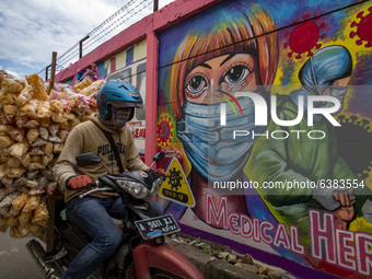 A man passing by the mural in Tangerang, Banten, Indonesia, 26 January 202. Indonesia reach out to 1 million of Covid19 positive case with t...