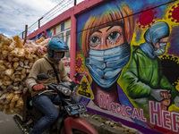 A man passing by the mural in Tangerang, Banten, Indonesia, 26 January 202. Indonesia reach out to 1 million of Covid19 positive case with t...
