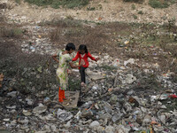 Children make their move as garbage seen burning beside the river Buriganga in Dhaka, Bangladesh on Saturday, January 30, 2021. (