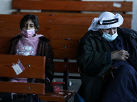 Palestinians wearing protective masks amid the COVID-19 pandemic, wait at the Rafah border crossing departure area to travel from the Gaza S...