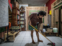 A Member of the boarding school cleaning the floor with tattoos al over his body. Islamic boarding school for punk and street children in Ru...