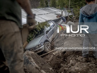 A man clearing mud from his car inSan Jose de Maipo, Chile, on February 1, 2021. The small town of San Alfonso was completely destroyed afte...