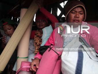 Indonesian women were in the car with a military truck carrying their belongings to be evacuated after the latest eruption of the Sinabung v...