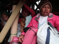 Indonesian women were in the car with a military truck carrying their belongings to be evacuated after the latest eruption of the Sinabung v...