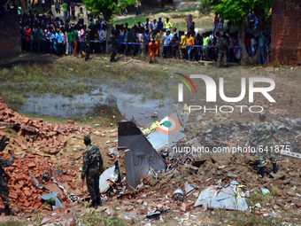 Indian people gather to see a glimpse of crashed Jaguar fighter plane of IAF,at Naini ,in Allahabad on June 16,2015. (