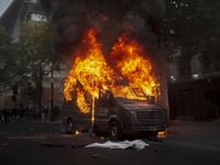 Police vehicle is attacked and burned and carabinero is injured after a new day of demonstrations in the center of Santiago de Chile, Chile,...