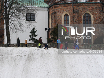 People are seen sledding down a hill near the Old Town in Warsaw, Poland on February 13, 2021. The Polish government announced this week the...