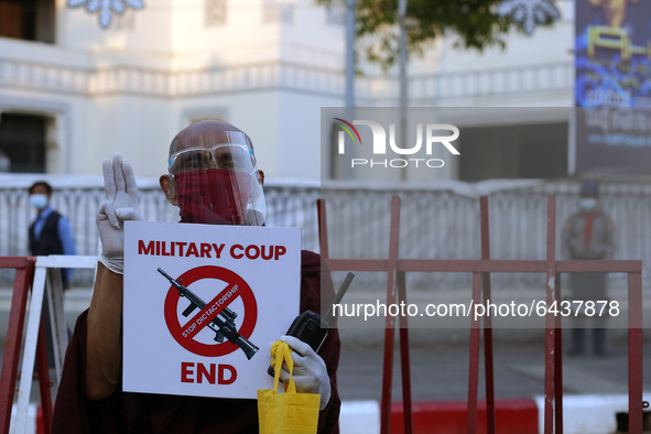A Myanmar buddhist monk holds a placard during a demonstration against the military coup in front of the City Hall in Yangon, Myanmar on Feb...