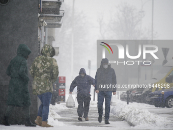 People are seen walking during heavy snowfall in Warsaw, Poland on February 17, 2021. Despite slowly rising temperatures heavy snowfall cont...