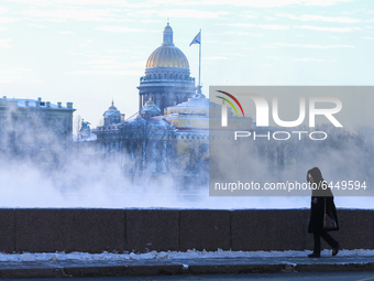 A woman walks past fog on the frozen Neva River in St. Petersburg. The air temperature dropped to -27 degrees.  (