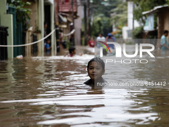 Residents wade floods at the residential areas in East Jakarta, on February 19, 2021. Floods was submerged some riverbanks areas in Jakarta...