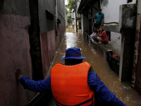 Air and Water Police officers using boat sweeping the residential to conduct evacuation as the floods hit the areas in East Jakarta, on Febr...