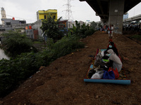 Residents flee to the high ground as their homes submerged by floods in East Jakarta, on February 19, 2021. Floods was submerged some riverb...