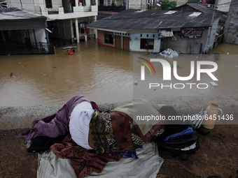 Residents flee to the high ground as their homes submerged by floods in East Jakarta, on February 19, 2021. Floods was submerged some riverb...