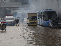 People wait for the water to subside as their vehicles are stuck on a flooded toll road following heavy rains in Jakarta, Indonesia, Saturda...