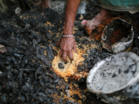 A slum dweller collects rice after a fire occurred at a slum in Dhaka, Bangladesh on February 21, 2021. At least 200 shanties were gutted in...