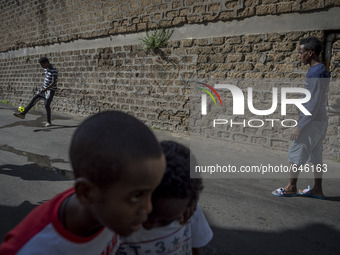 Refugees play outside the Humanitarian emergency reception centre for immigrants, Baobab, close Tiburtina train station in Rome, Italy on Ju...