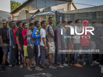 Refugees ready to eat outside the Humanitarian emergency reception centre for immigrants, Baobab, close Tiburtina train station in Rome, Ita...