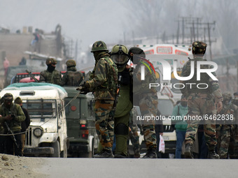 Indian soldiers escort a member of bomb disposal squad at Patha Chowk-Nowgam road in Srinagar,Kashmir on February 22, 2021.An Improvised Exp...