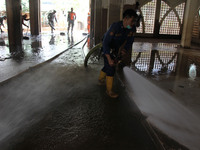 Officers clean up a house of worship (Mosque) in a residential area hit by two meter flood in Cipinang Melayu, Jakarta, on February 22,2021....